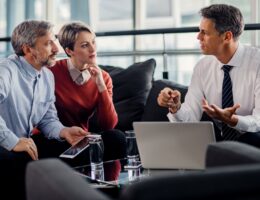 Insurance agent talking to mid adult couple on a meeting in the office.