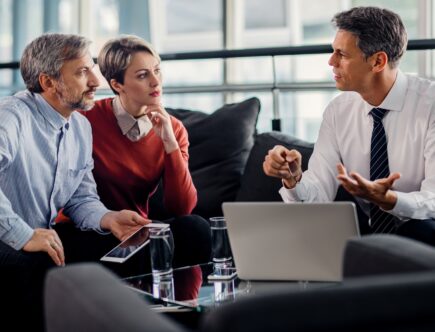 Insurance agent talking to mid adult couple on a meeting in the office.