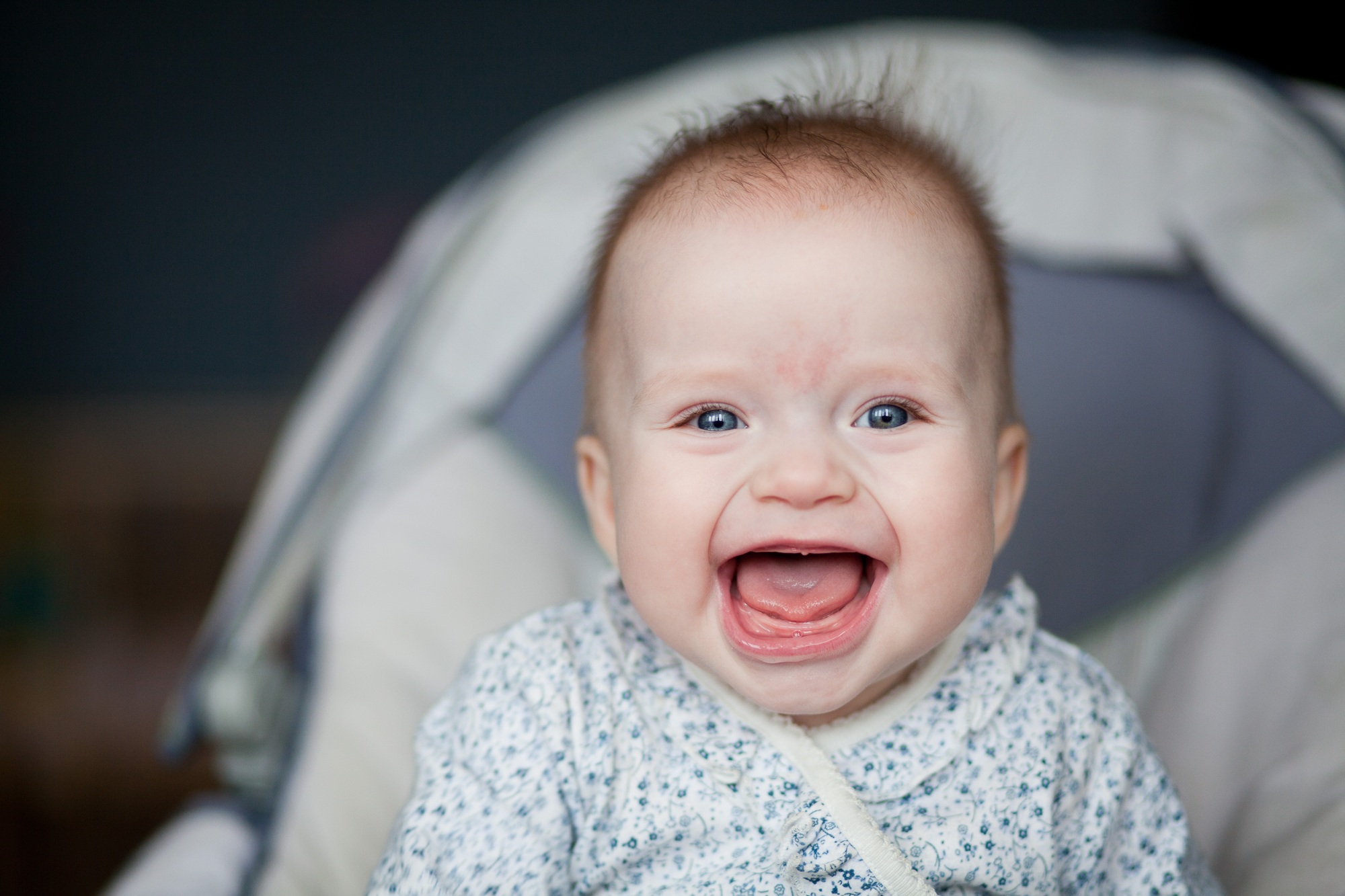 Portrait of adorable smiling baby infant showing first teeth.