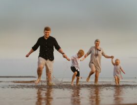 nice caucasian family having fun running in sea on sunset.Summer vacation with kids