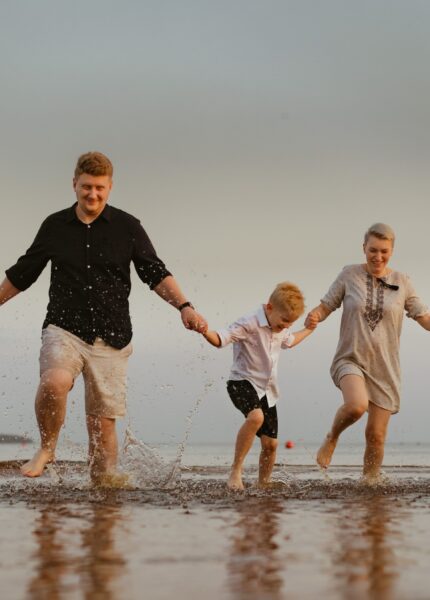 nice caucasian family having fun running in sea on sunset.Summer vacation with kids